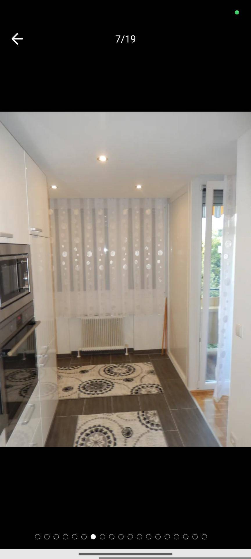 Küchenbereich mit Fenster, Heizkörper und Zugang zu einem weiteren Raum oder nach draußen.