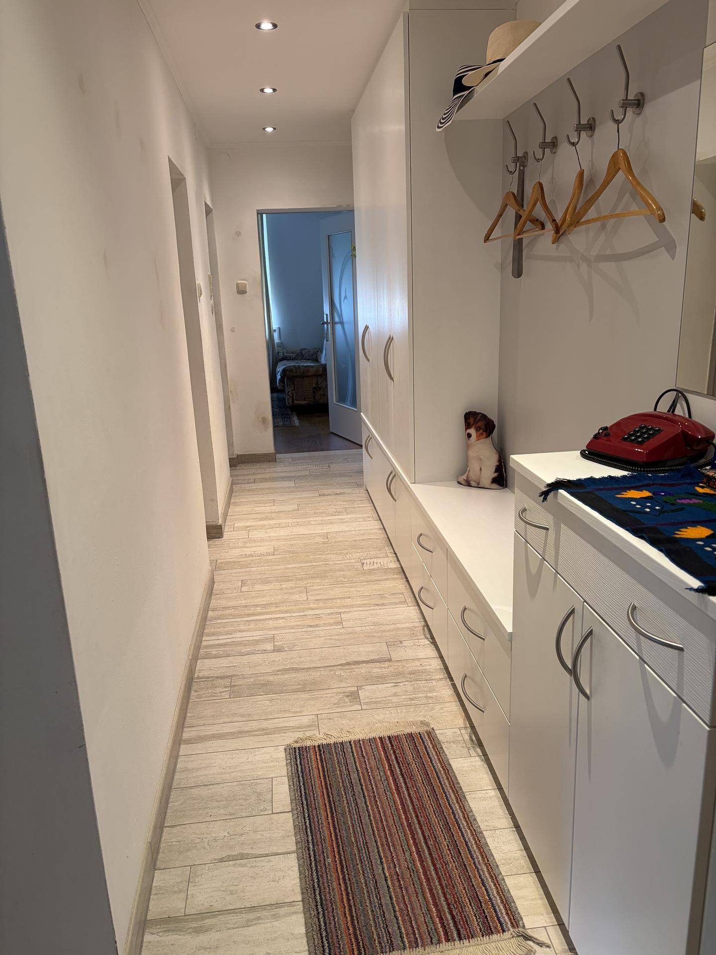 Heller Flur mit Einbauschränken, Garderobe und hellem Fliesenboden.