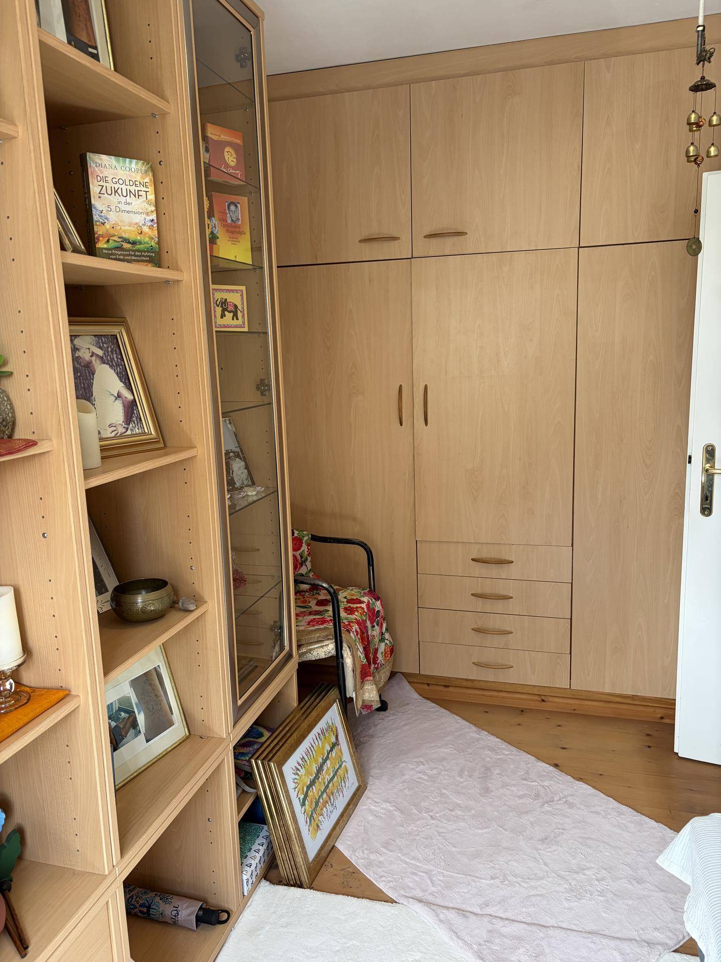 Schlafzimmer mit Einbauschränken, Bücherregal und hellem Holzfußboden.