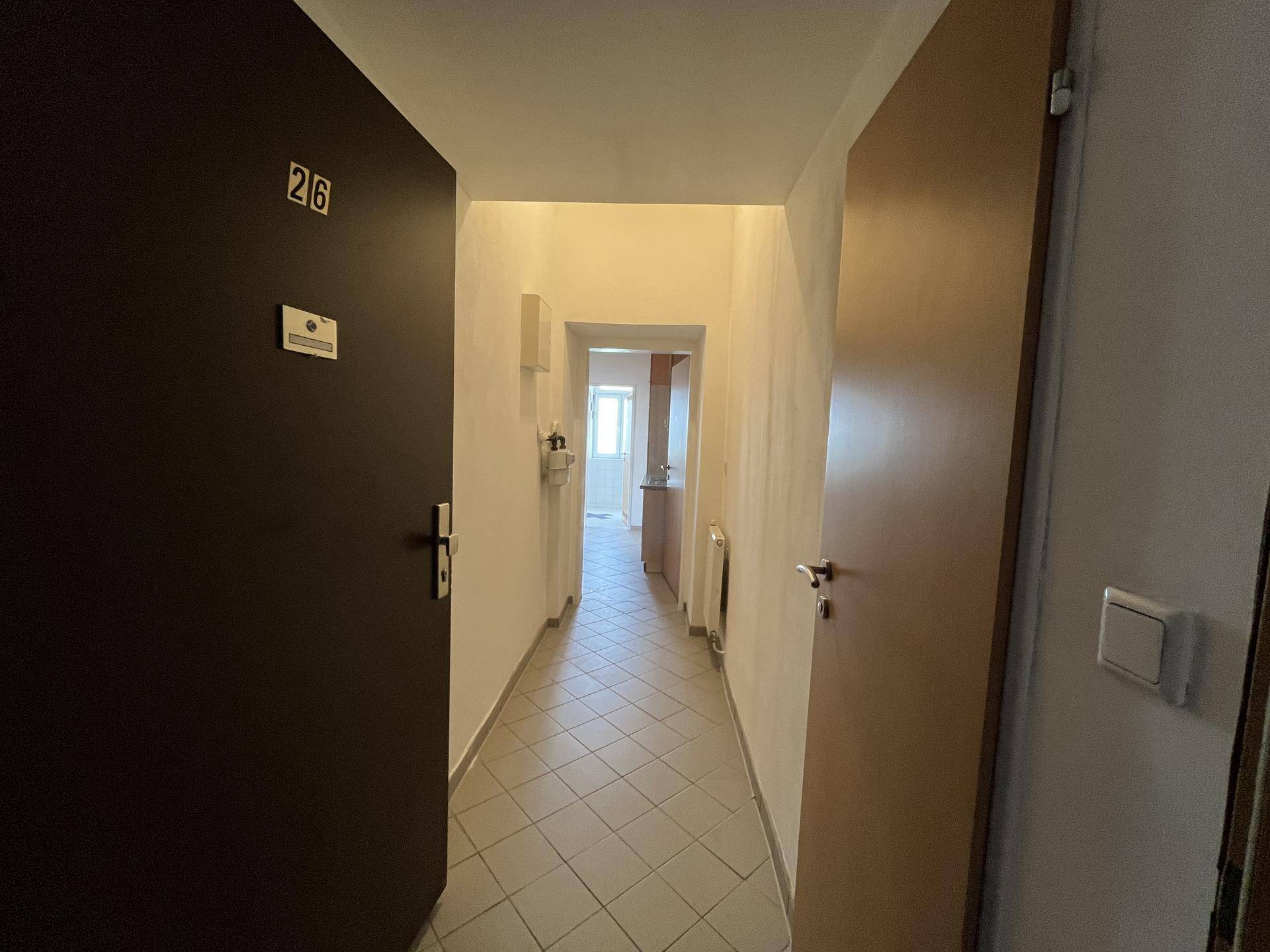 Langer Flur mit Fliesenboden und Zugang zu verschiedenen Räumen der Wohnung.