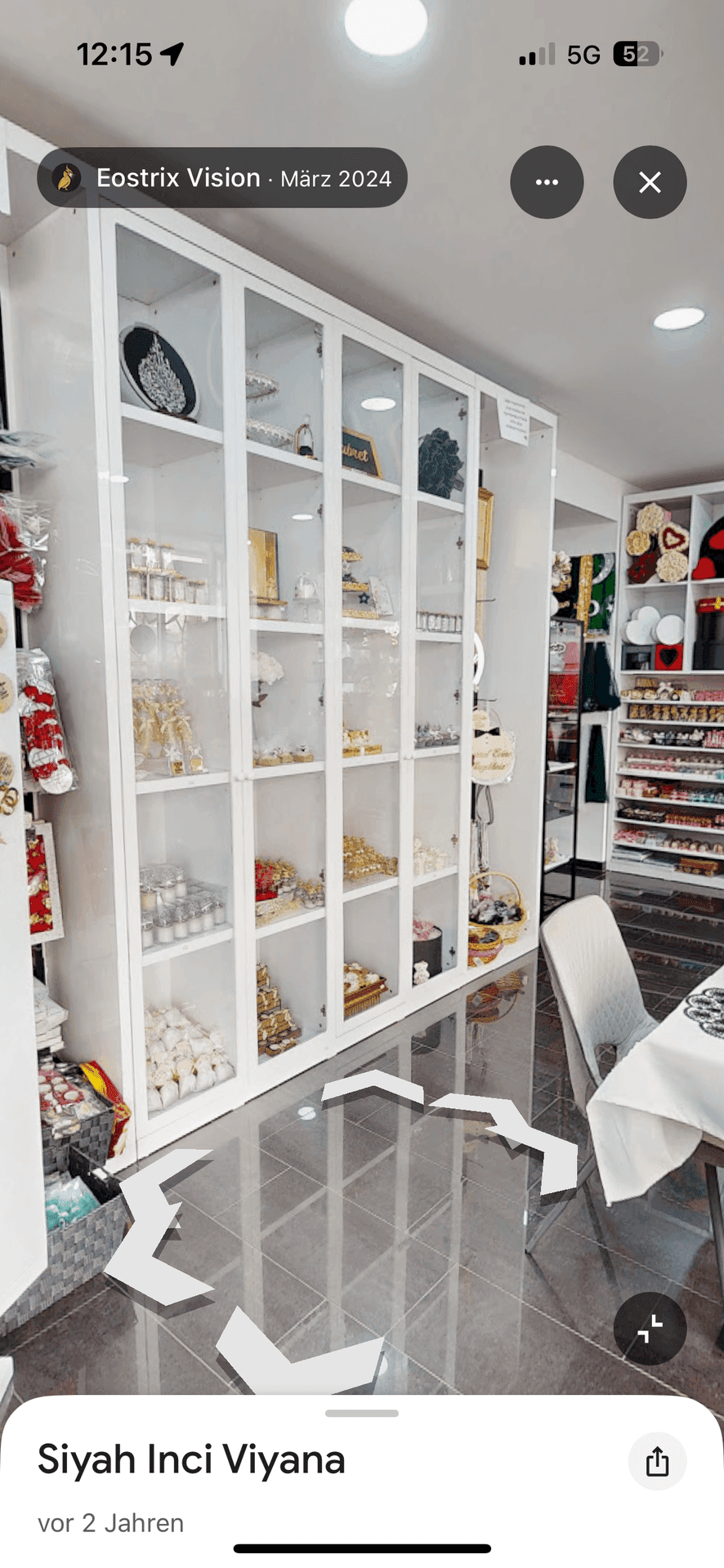 Großer weißer Vitrinenschrank mit Glasfronten, gefüllt mit dekorativen Artikeln in einem Verkaufsraum.