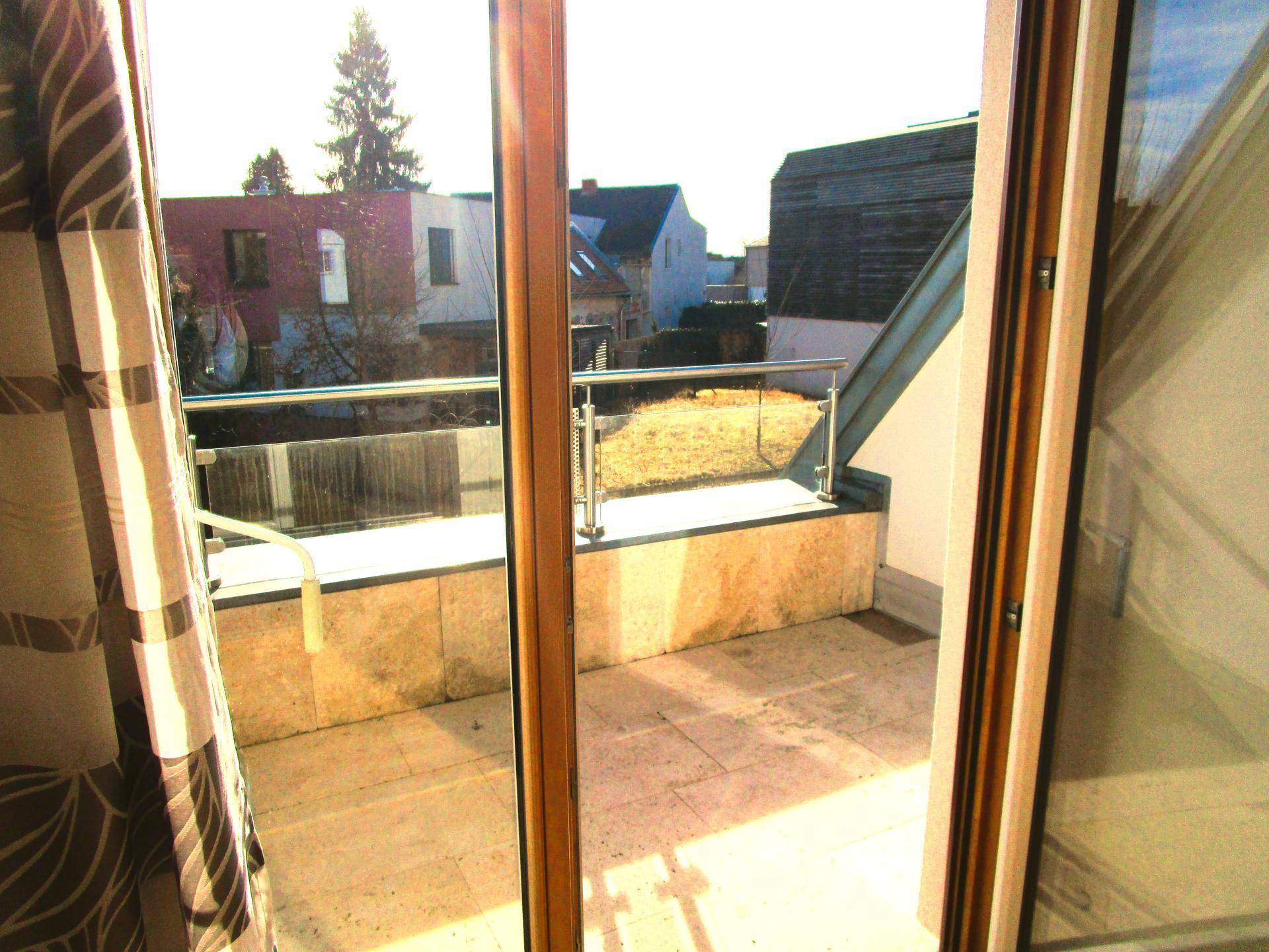 Kleiner Balkon mit Fliesenboden und Metallgeländer, bietet einen Blick ins Grüne.