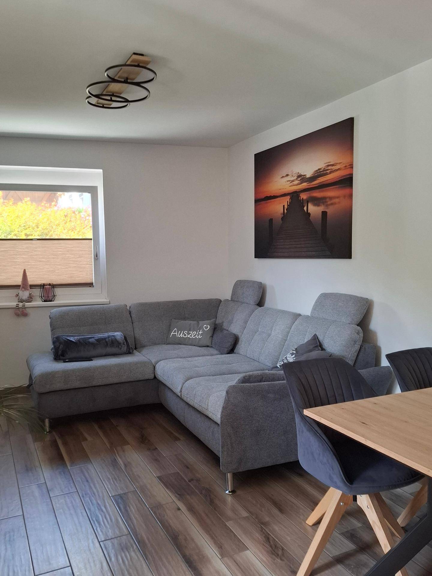 Gemütlicher Wohnbereich mit Ecksofa, Holzboden und Essbereich, ideal für entspannte Stunden.