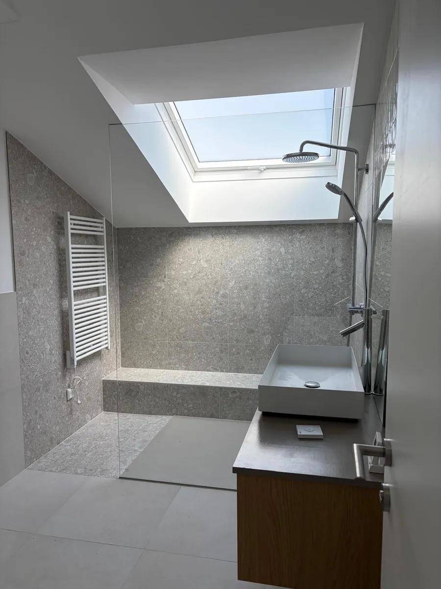 Modernes Badezimmer mit begehbarer Dusche, Dachfenster und beheiztem Handtuchhalter.