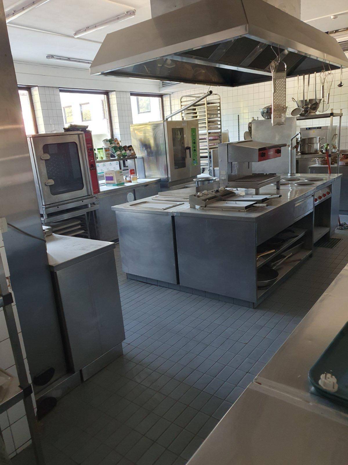 Große Industrieküche mit Edelstahlgeräten und Fliesenboden, ideal für Gastronomiebetriebe.