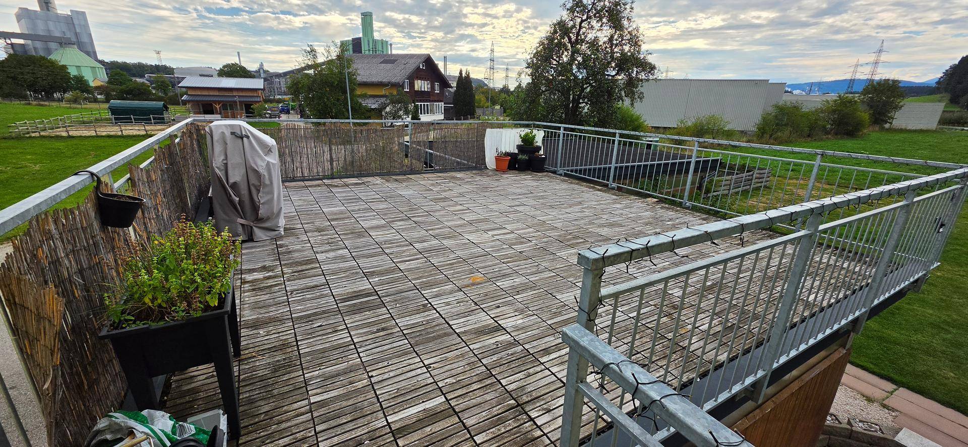 Große Dachterrasse mit Holzdielen und weitem Blick über die Umgebung.