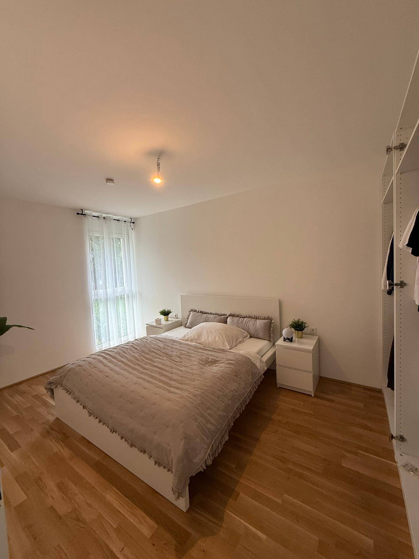 Geräumiges Schlafzimmer mit Holzboden, Doppelbett und integriertem Kleiderschrank.