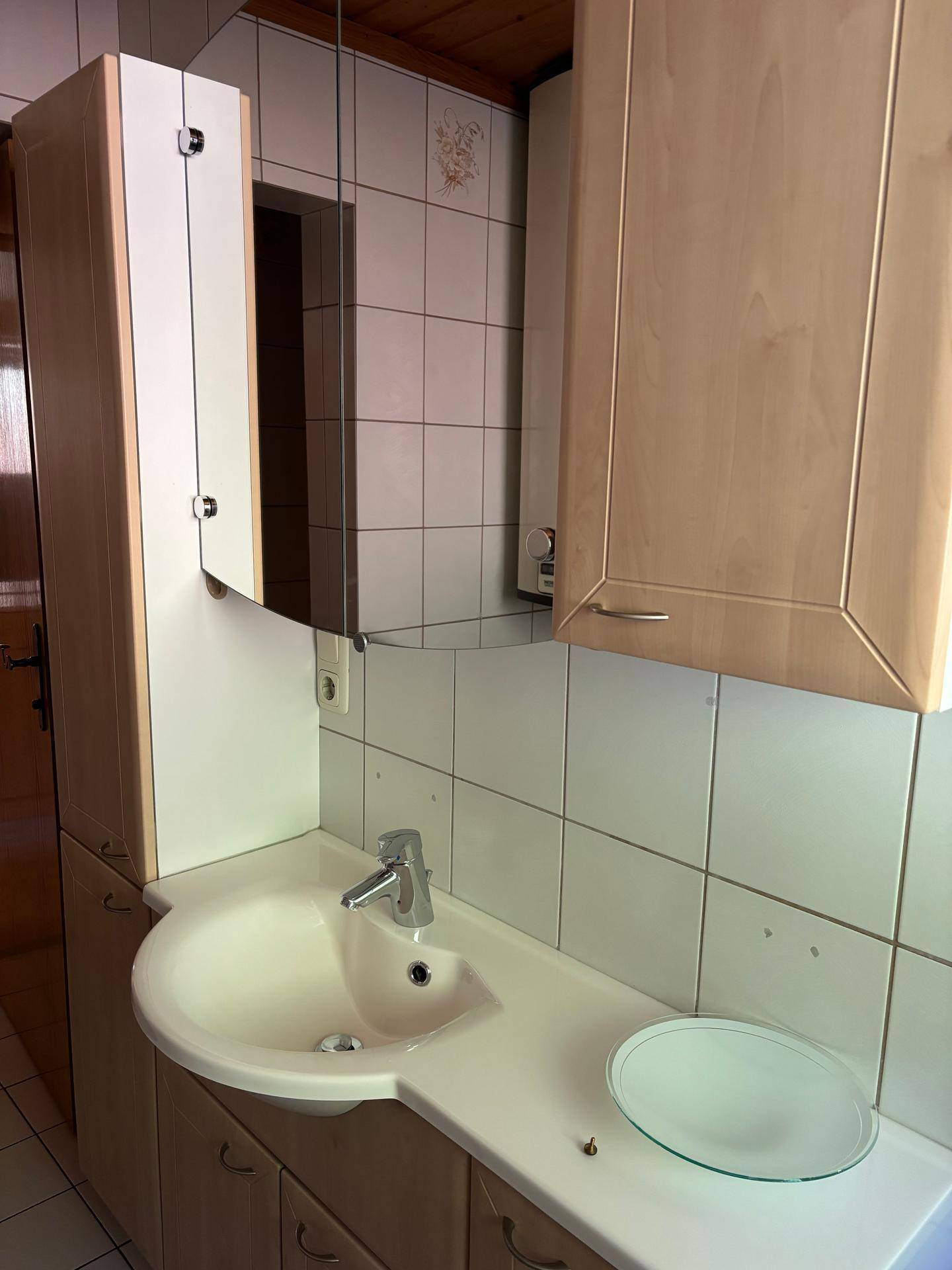 Detailansicht des Badezimmerwaschtisches mit integriertem Spiegelschrank und modernen Armaturen.