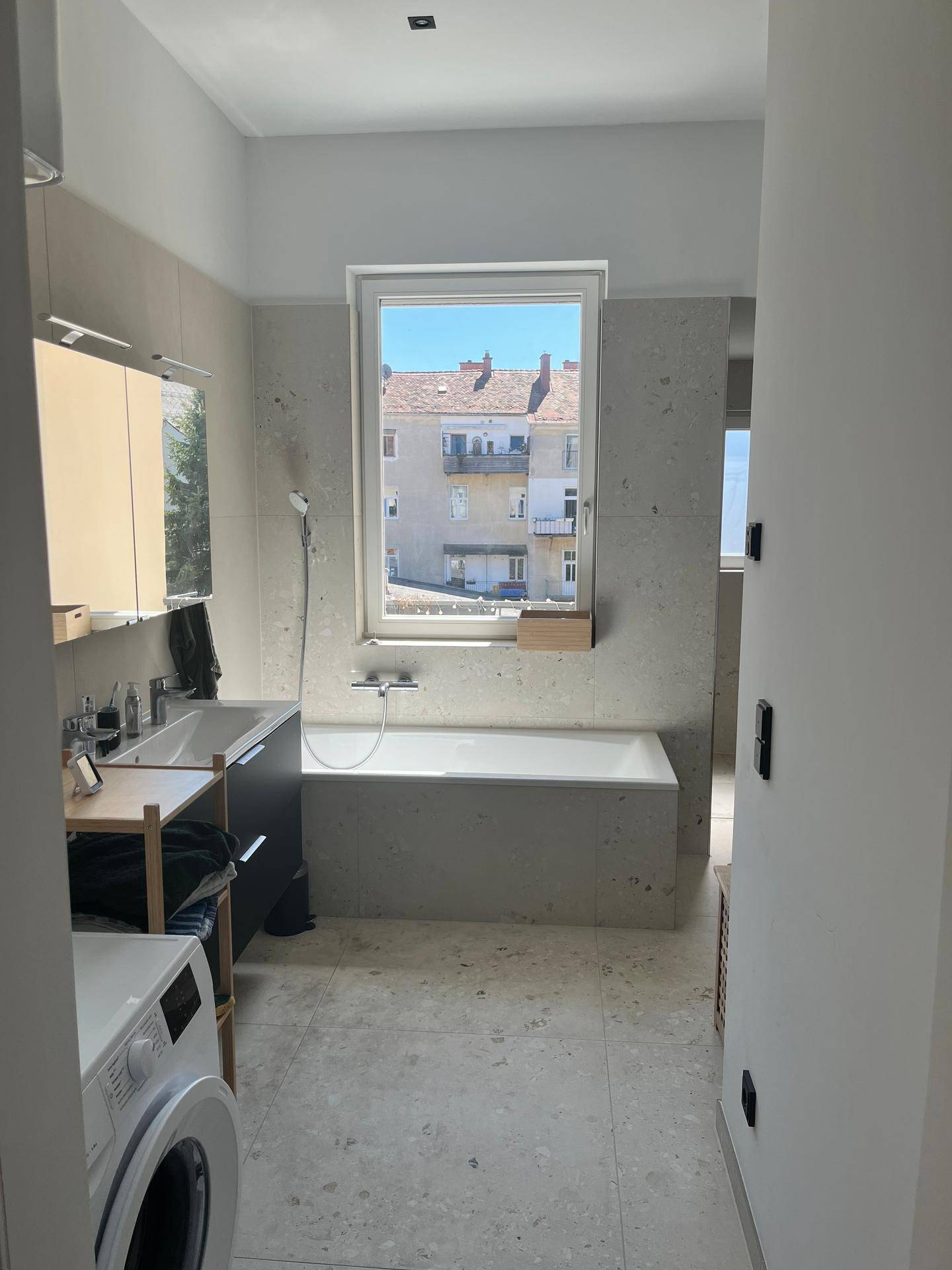 Geräumiges Badezimmer mit Badewanne, Doppelwaschbecken und Waschmaschine.