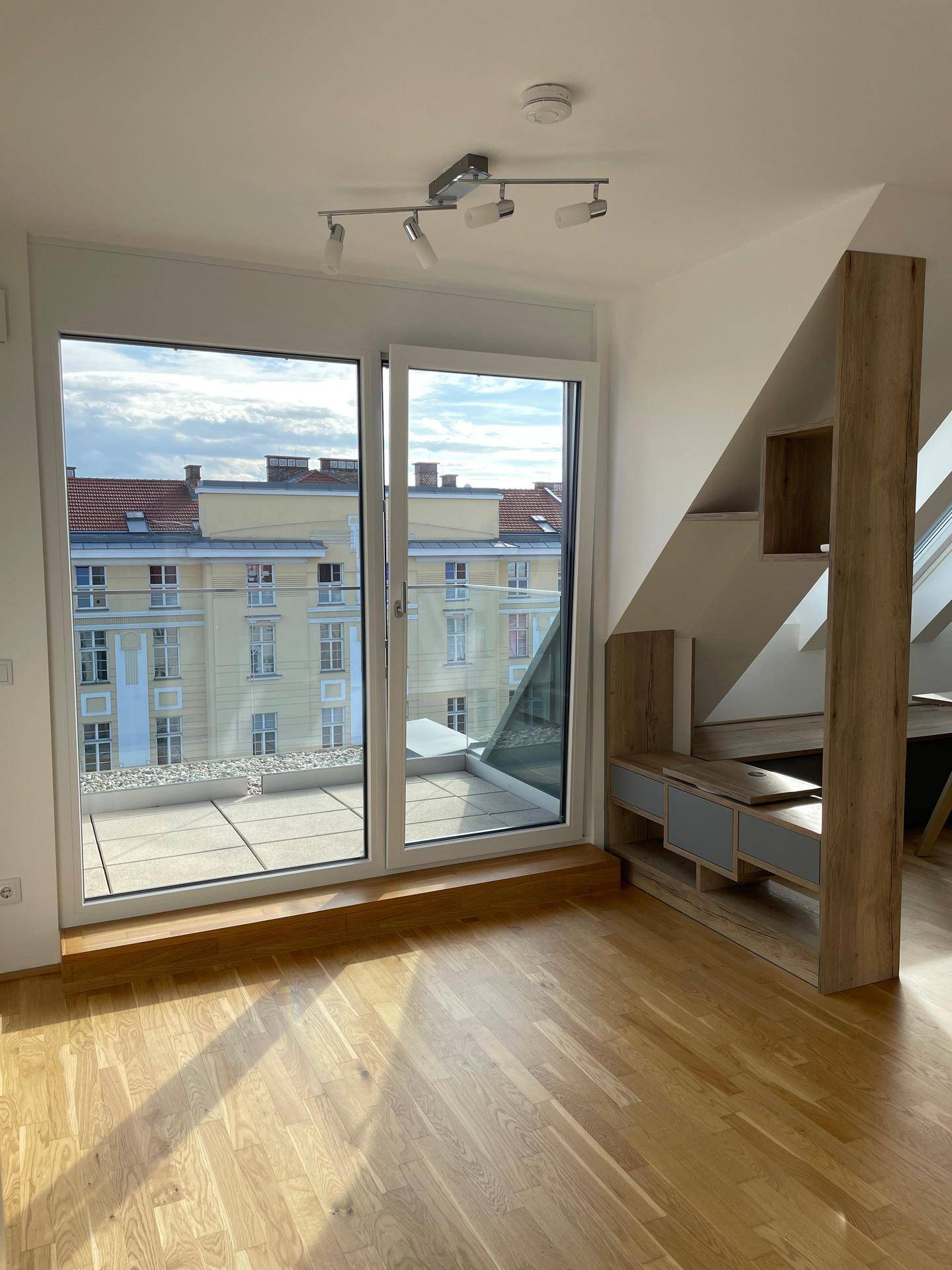Lichtdurchfluteter Raum mit großen Schiebetüren und direktem Zugang zur sonnigen Terrasse.