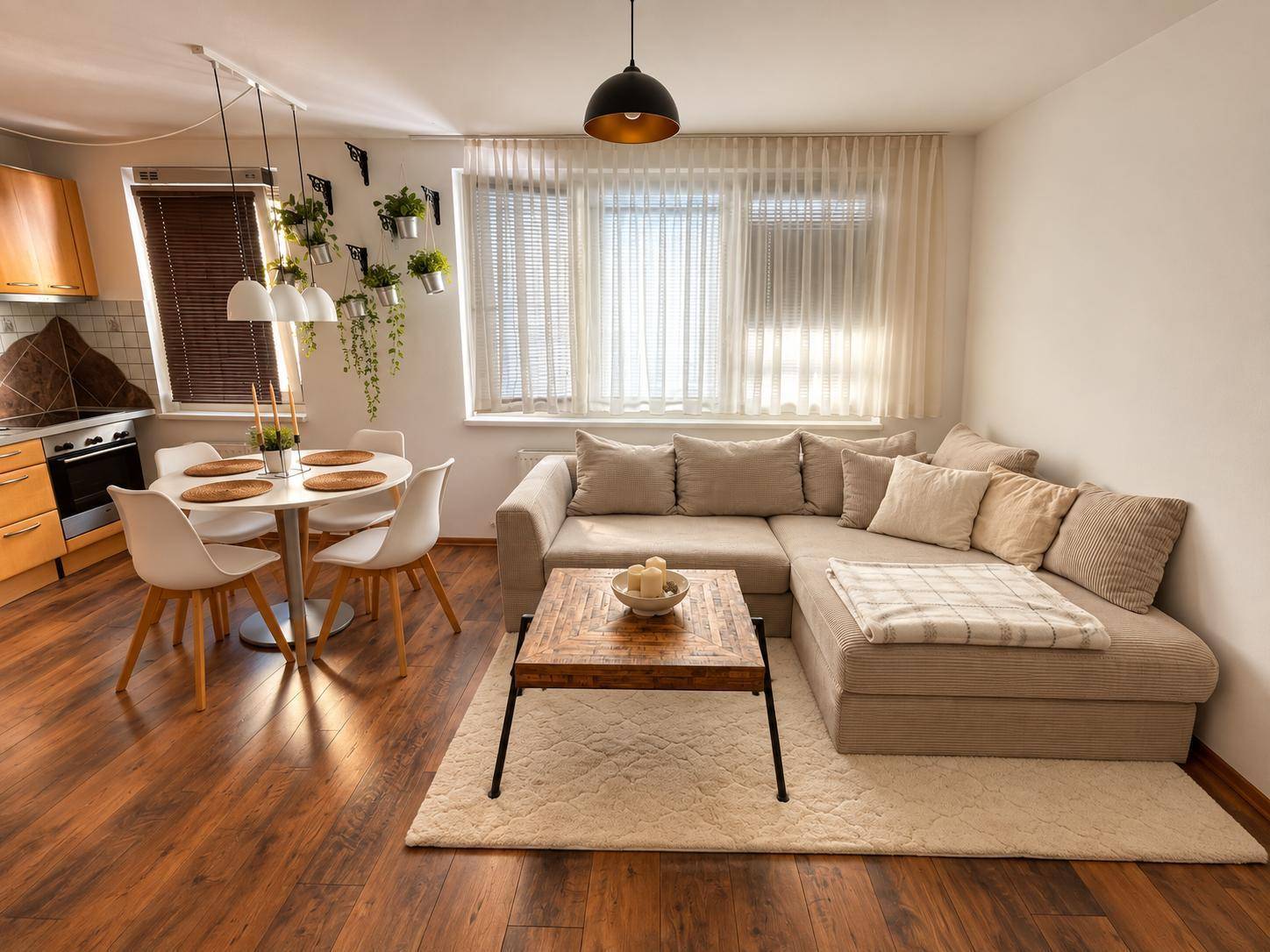 Gemütlicher Wohnbereich mit Ecksofa und Essplatz, verbunden mit der Küche.