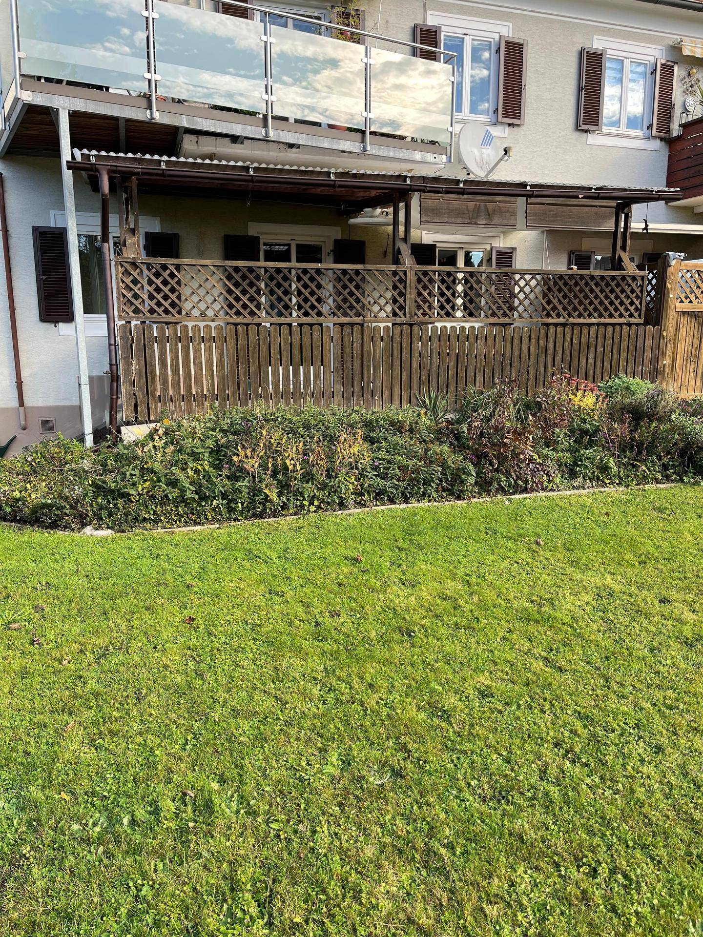 Gepflegter Gartenbereich mit Rasenfläche und Blick auf die Hausfassade.