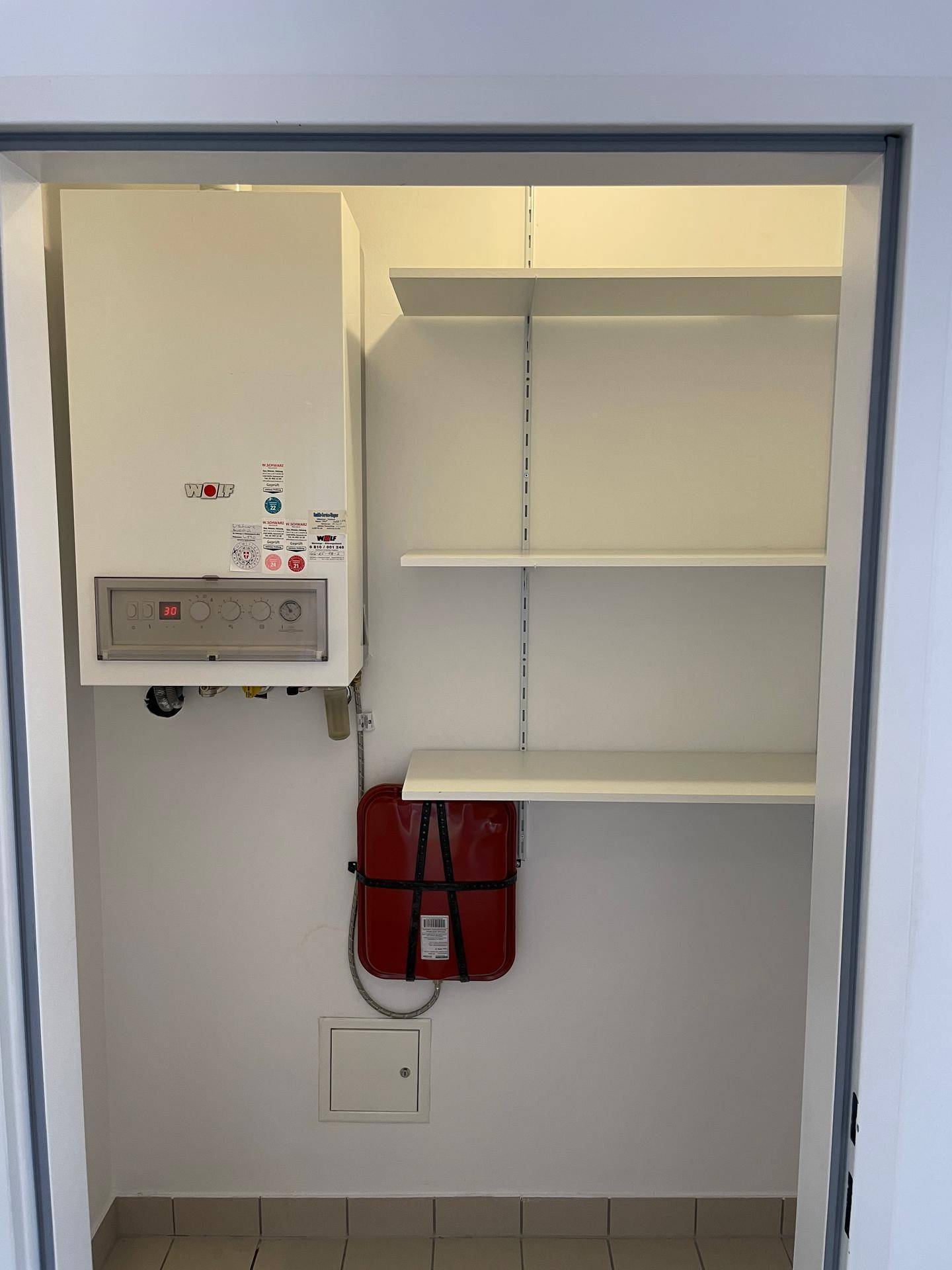 Hauswirtschaftsraum mit Heizungsanlage, Boiler und praktischen Regalen.