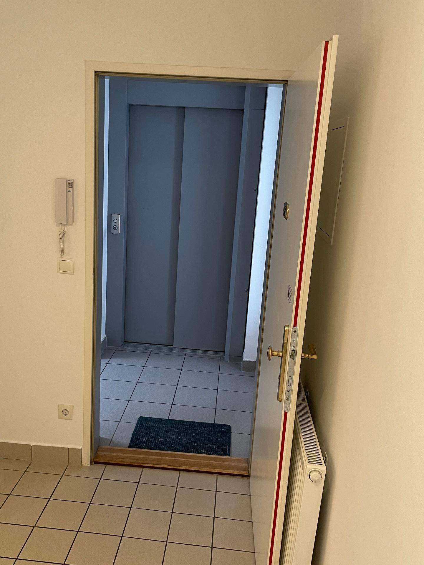 Eingangsbereich der Wohnung mit Fliesenboden und direktem Zugang zum Aufzug.