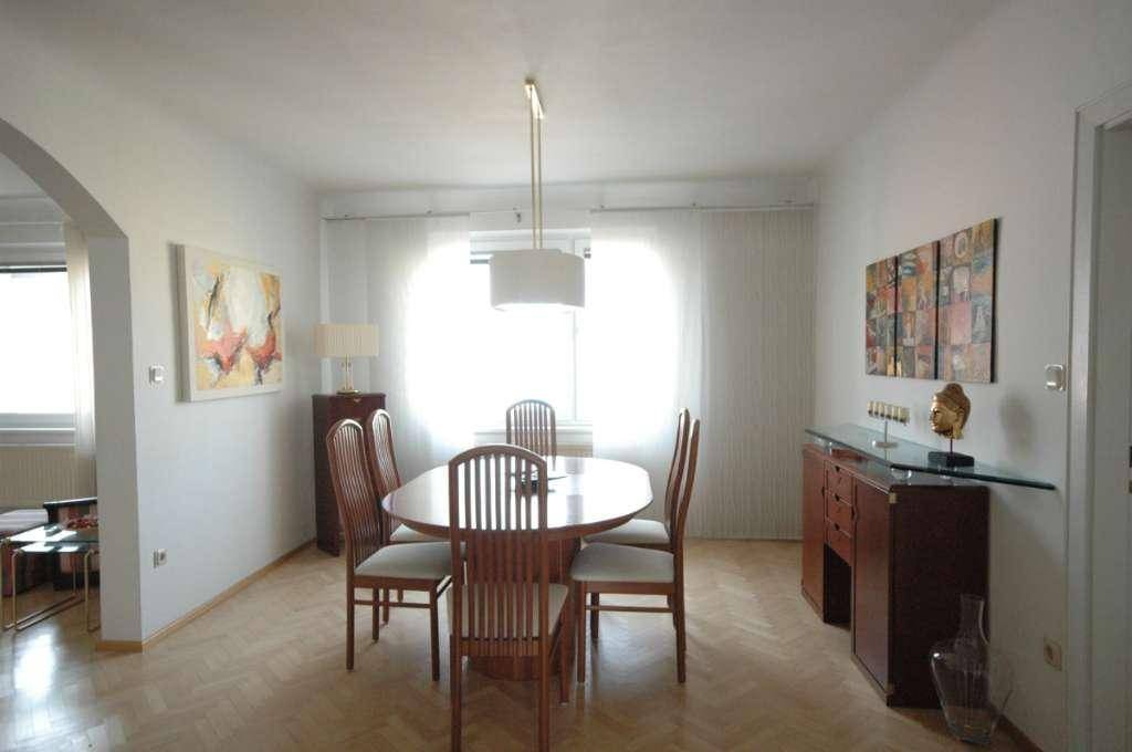Eleganter Essbereich mit Holztisch, passenden Stühlen und dekorativen Elementen.