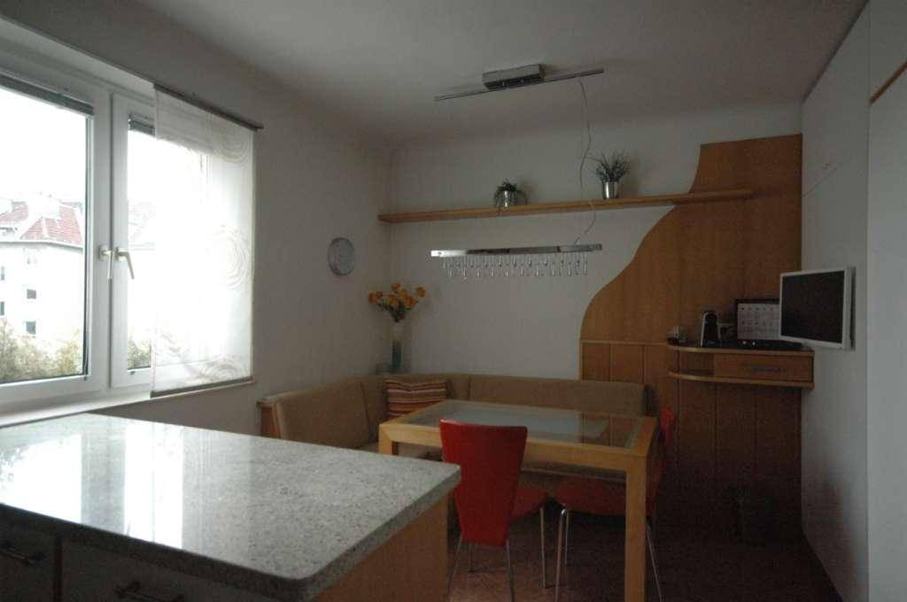 Gemütliche Wohnküche mit Essecke, Granitarbeitsplatte und Fensterblick.