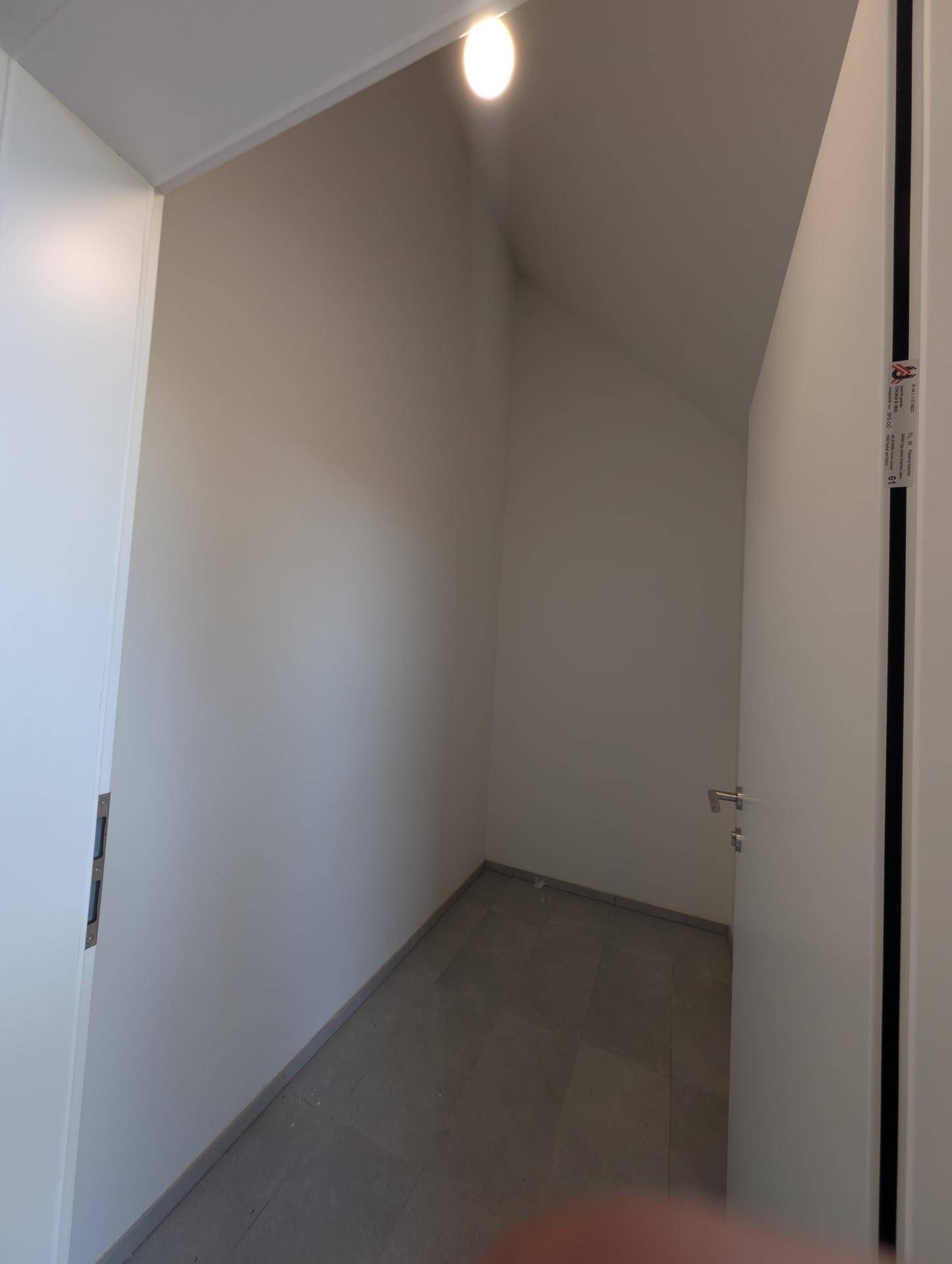 Kleiner Abstellraum mit schräger Decke und Fliesenboden, ideal für zusätzlichen Stauraum.