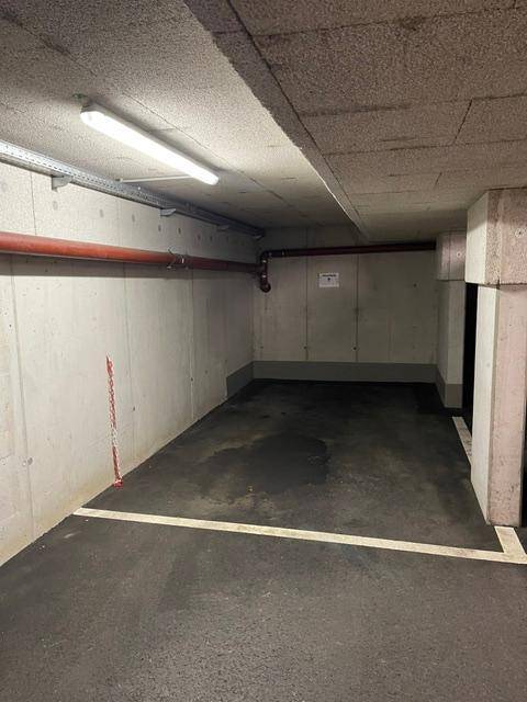Ein weiterer Tiefgaragenstellplatz in einem funktionalen Bereich mit Betonstrukturen und einfacher Beleuchtung.