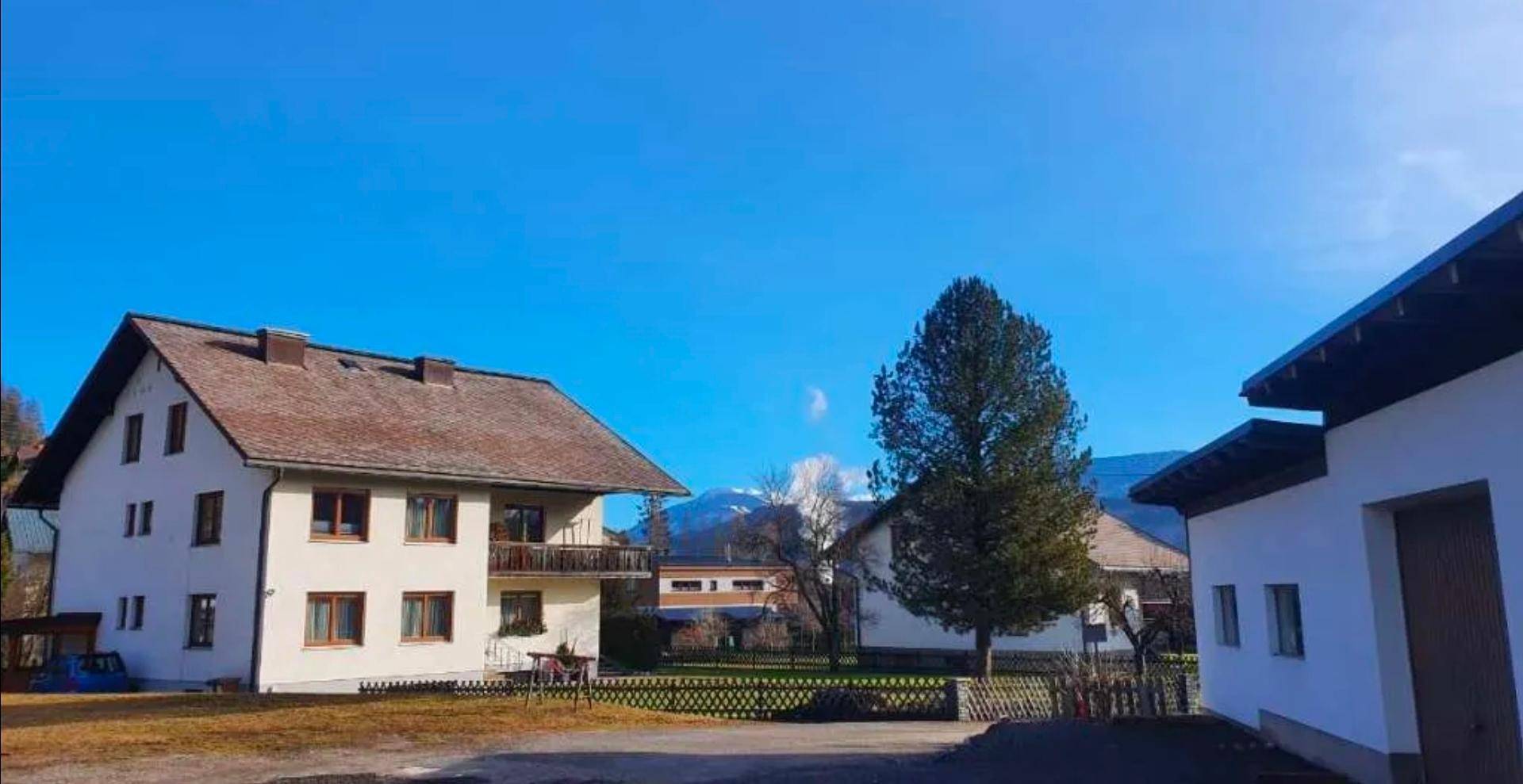Traditionelles Wohnhaus mit Balkon und Blick auf die umliegende Berglandschaft.