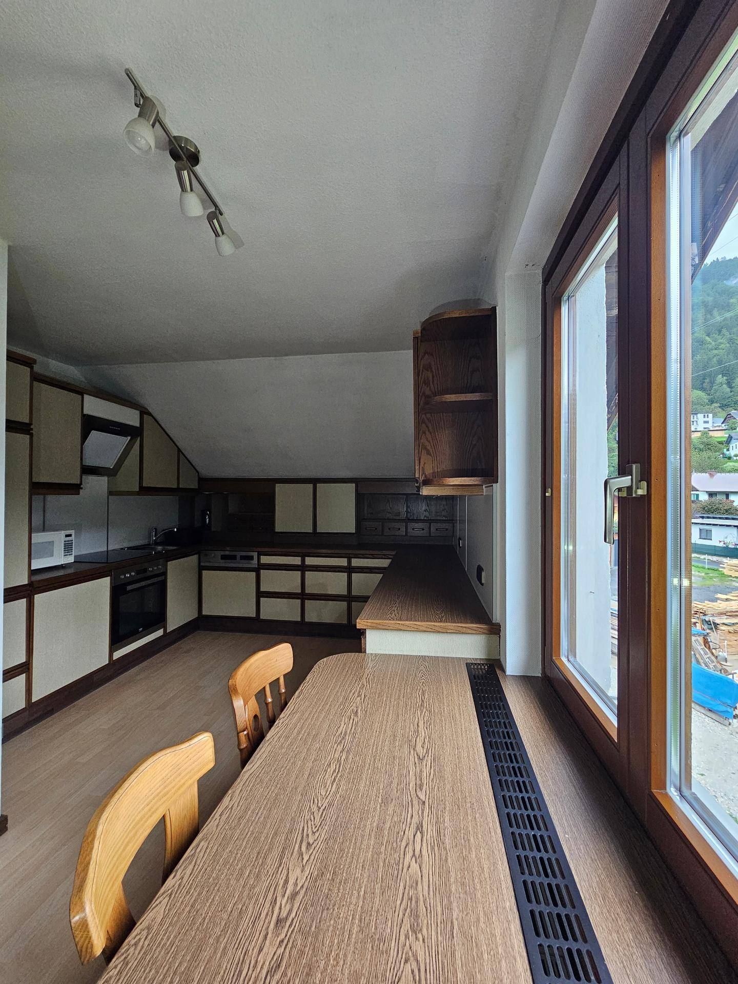 Küche im Dachgeschoss mit Einbauküche, Essbereich und Fenster mit Ausblick.