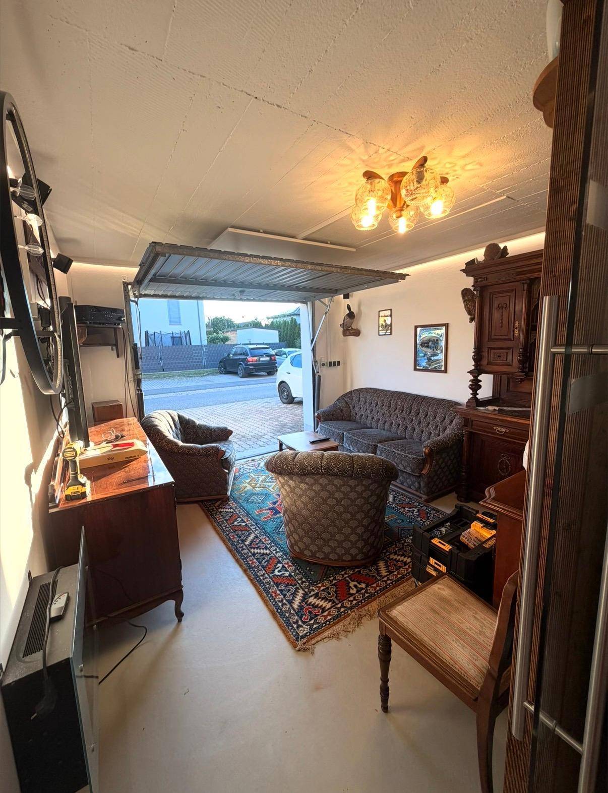 Als Wohnraum umfunktionierte Garage mit Vintage-Möbeln und Blick auf die Straße.