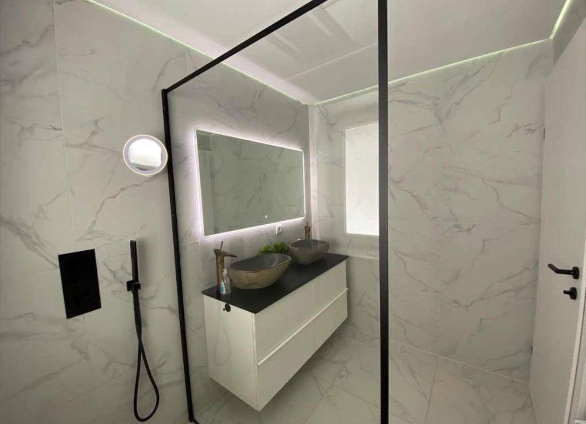 Geräumiges modernes Badezimmer mit begehbarer Dusche und zwei stilvollen Waschbecken.
