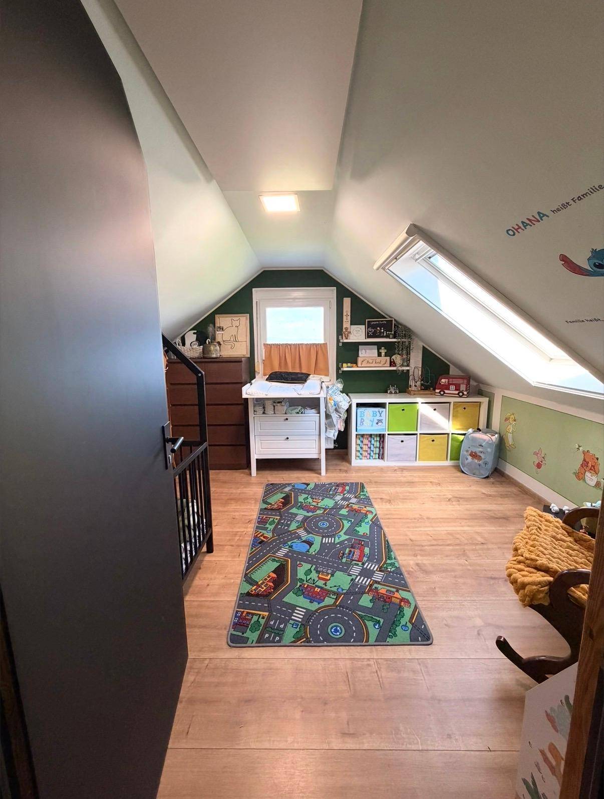 Helles Kinderzimmer im Dachgeschoss mit Schrägdach, Dachfenster und Laminatboden.