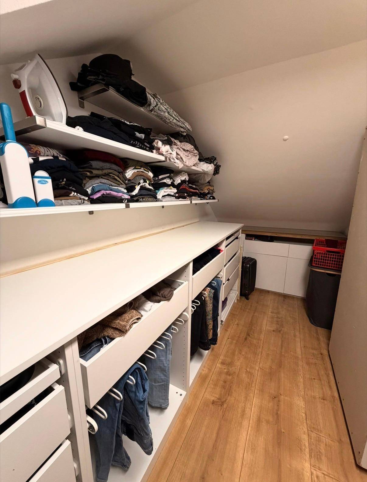 Weiterer Blick in den begehbaren Kleiderschrank mit Schubladen und Regalsystemen.
