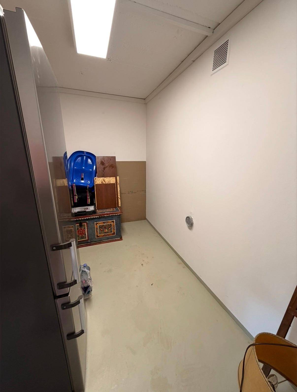 Weiterer Blick in den praktischen Abstellraum mit Kühlschrank und Stauraum.