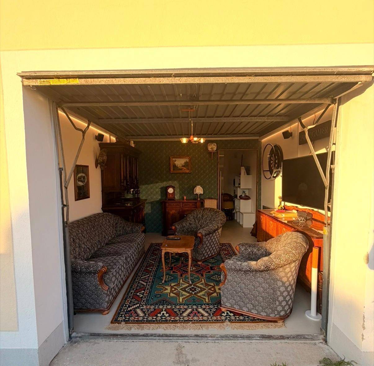 Außenansicht einer Garage, die als gemütlicher Wohnraum mit Vintage-Möbeln genutzt wird.