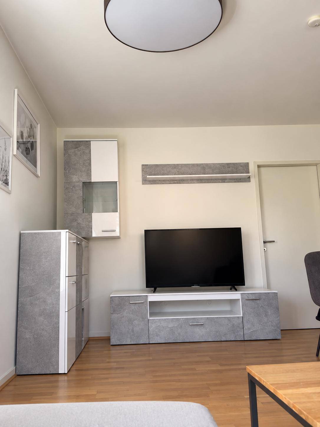 Wohnzimmer mit TV-Möbeln in modernem Design und hellem Laminatboden.