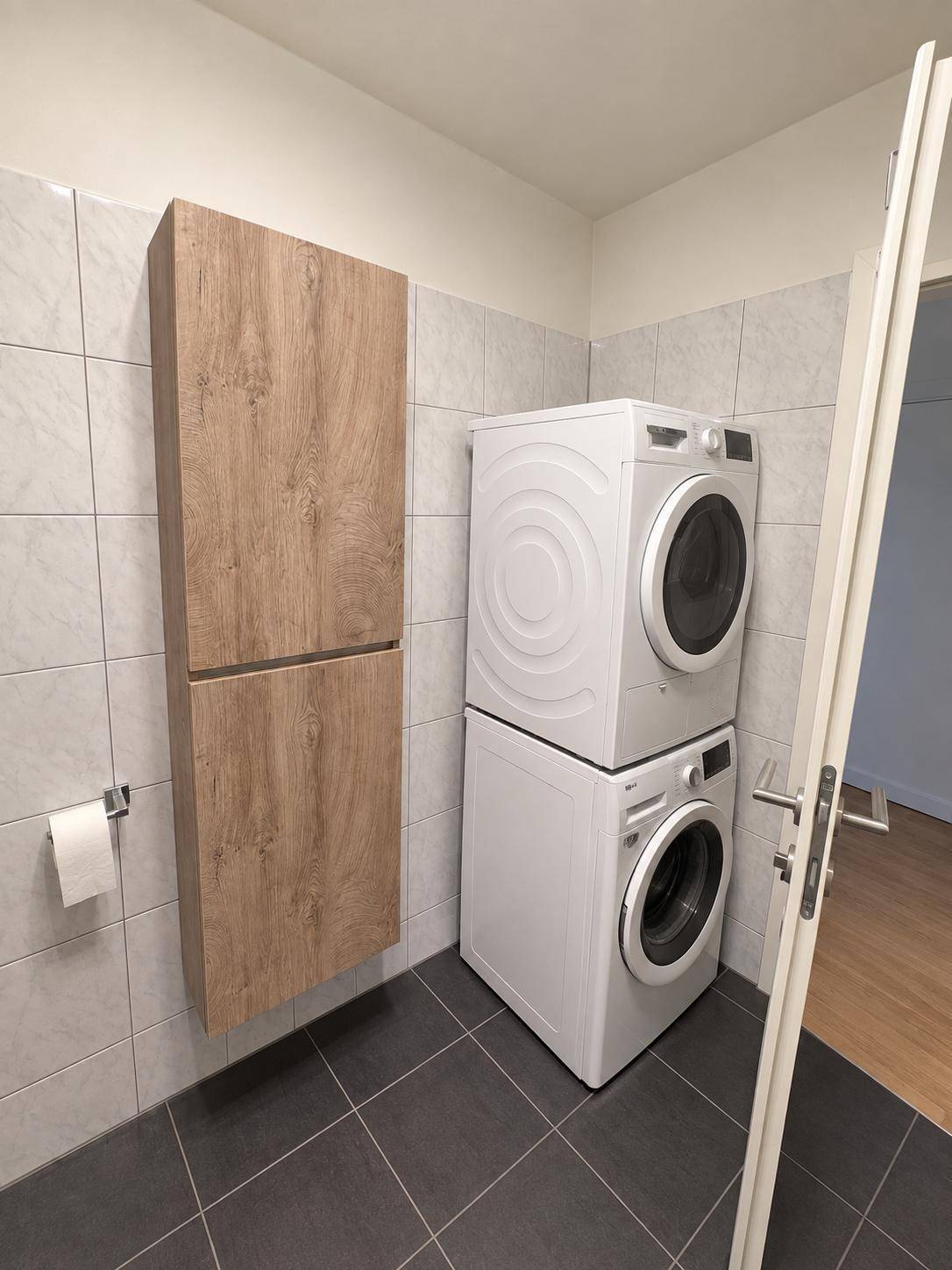 Praktischer Hauswirtschaftsraum mit Waschmaschine, Trockner und zusätzlichem Stauraum.