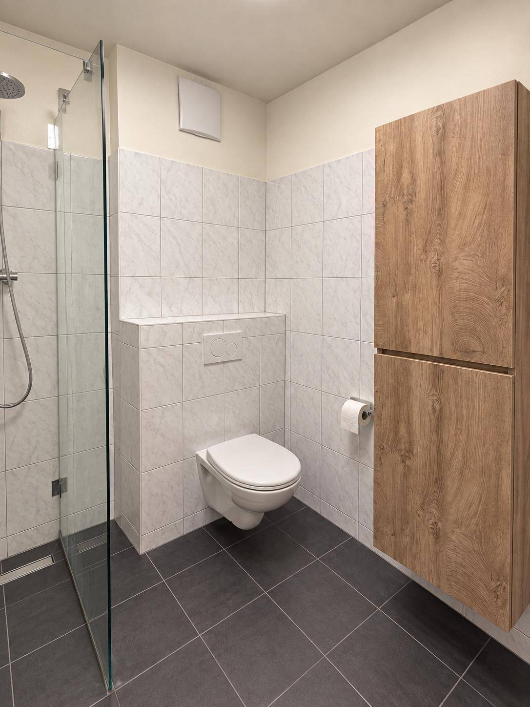 Modernes Badezimmer mit bodengleicher Dusche, wandhängendem WC und Holzschrank.