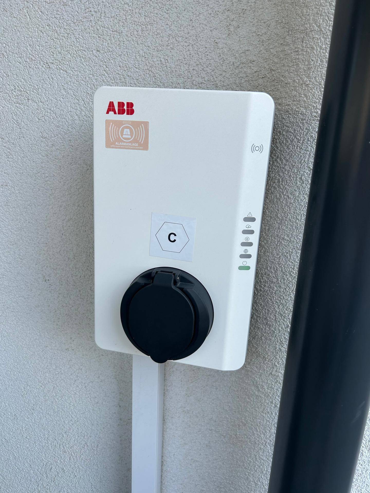 Nahaufnahme einer ABB Ladestation für Elektrofahrzeuge an der Außenwand des Gebäudes.