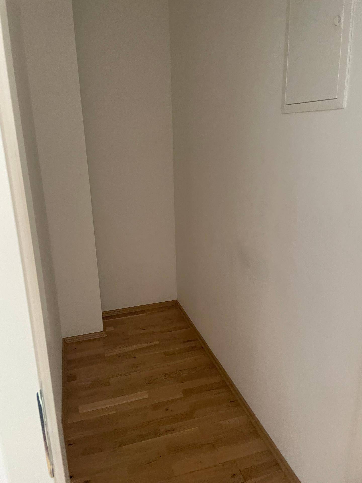 Praktischer Abstellraum mit Parkettboden und weißen Wänden, ideal für zusätzlichen Stauraum.