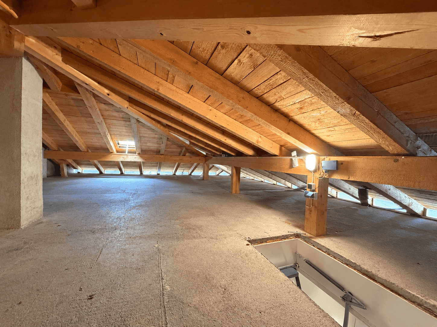 Dachboden mit sichtbaren Holzbalken und viel Potenzial für Ausbau.
