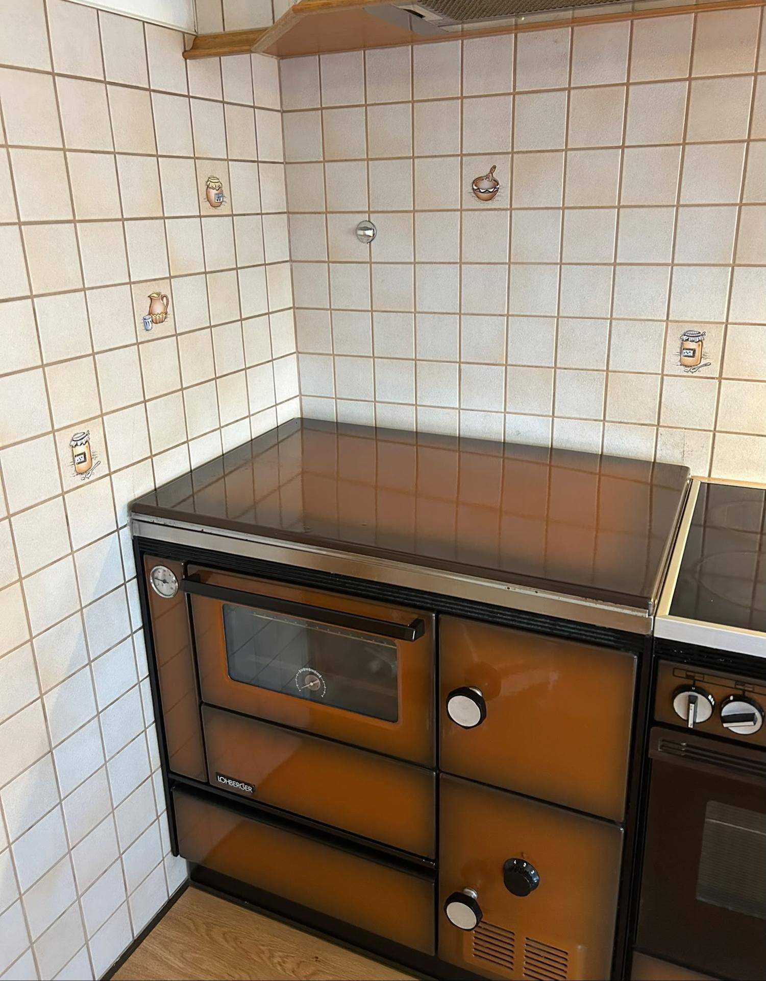 Traditionelle Küche mit einem klassischen Herd und Ofen sowie gefliesten Wänden.