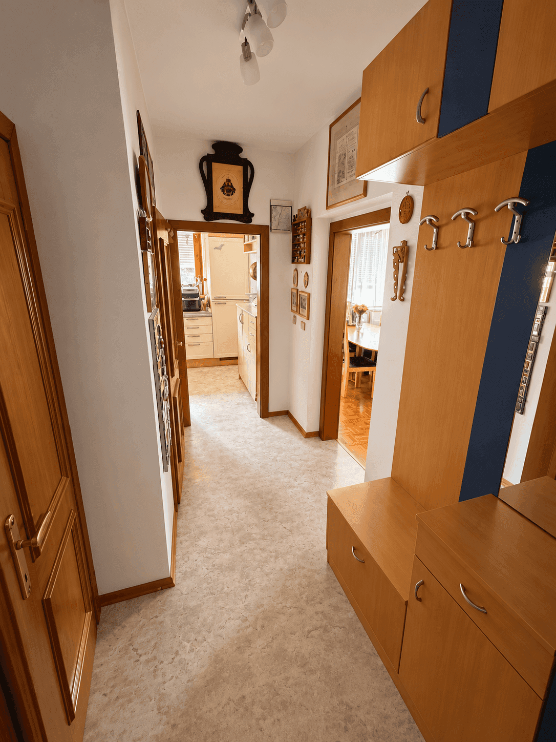 Langer Flur mit integrierter Garderobe und Zugang zu weiteren Räumen, funktional und hell.