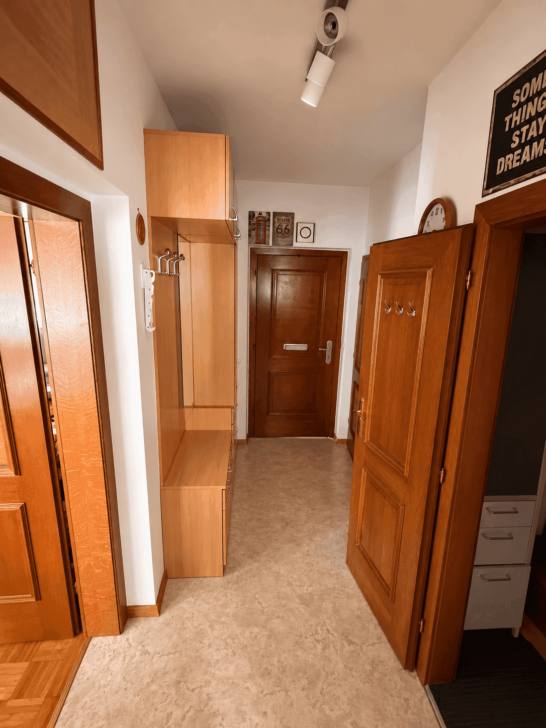 Heller Flur mit Garderobe und Holzmöbeln, bietet einen freundlichen Empfangsbereich.
