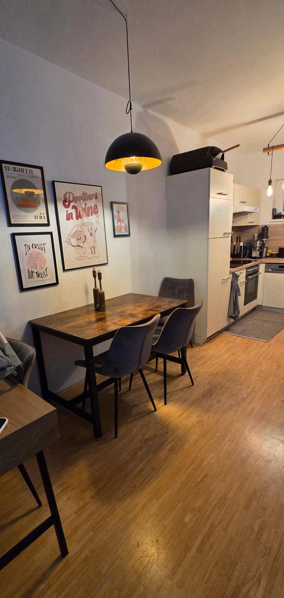 Essbereich mit Holztisch und modernen Stühlen, angrenzend an die Küche.