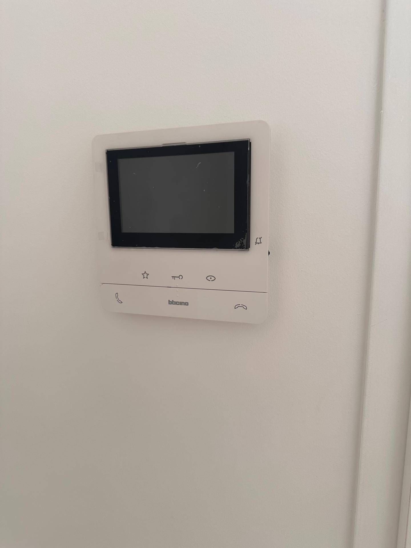 Modernes Video-Gegensprechanlagensystem an einer weißen Wand im Eingangsbereich der Wohnung.