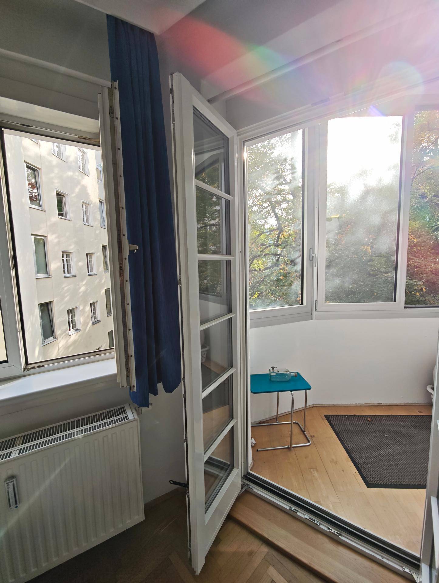 Verglaste Loggia mit Zugang vom Innenraum, bietet einen sonnigen Platz mit Baumblick.
