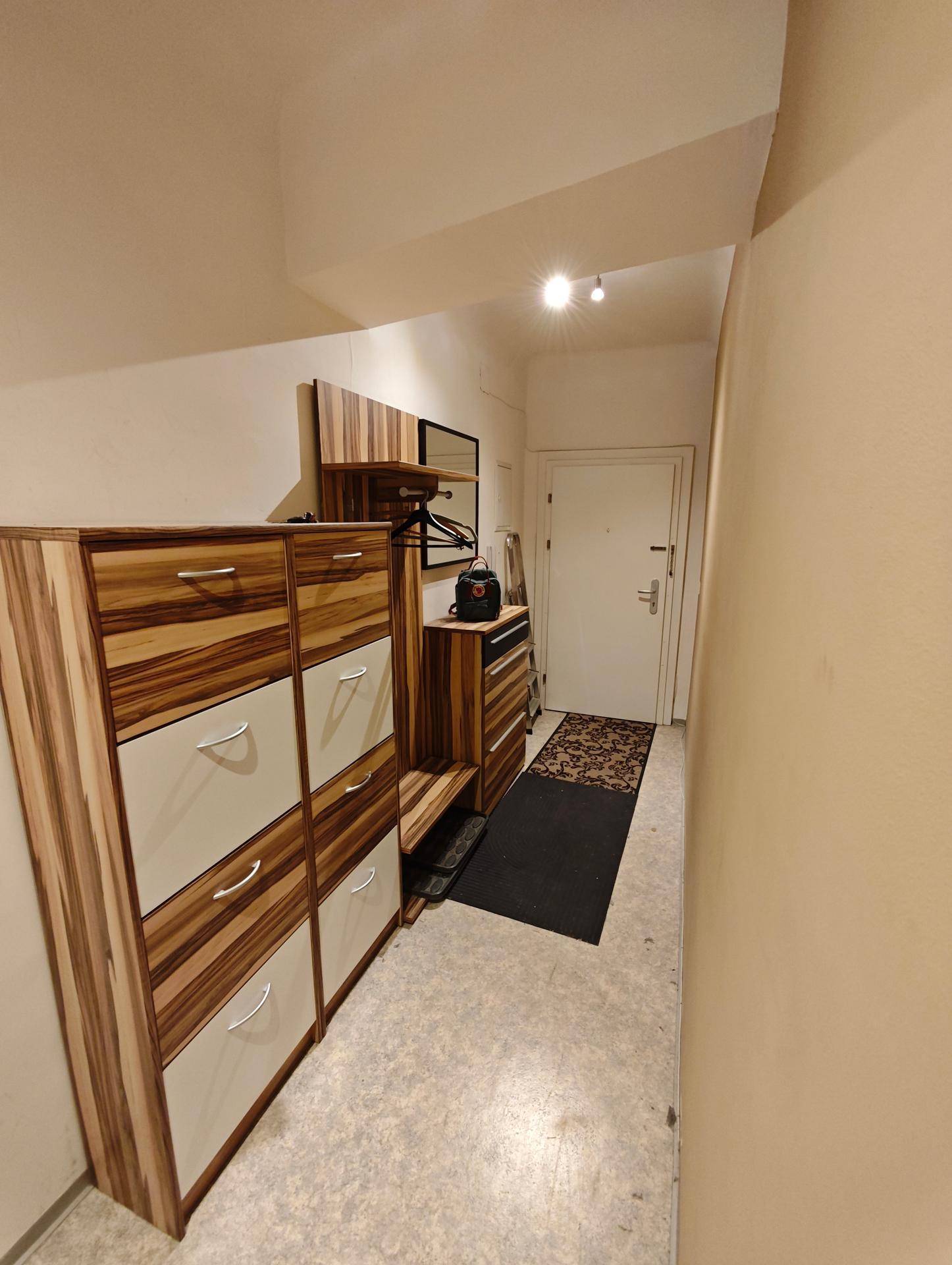 Heller Flur mit modernem Schuhschrank und Garderobe, der zum Eingangsbereich führt.