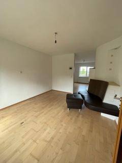 Wohnzimmer mit Parkettboden und einer modernen Sitzgelegenheit neben dem Kaminofen.