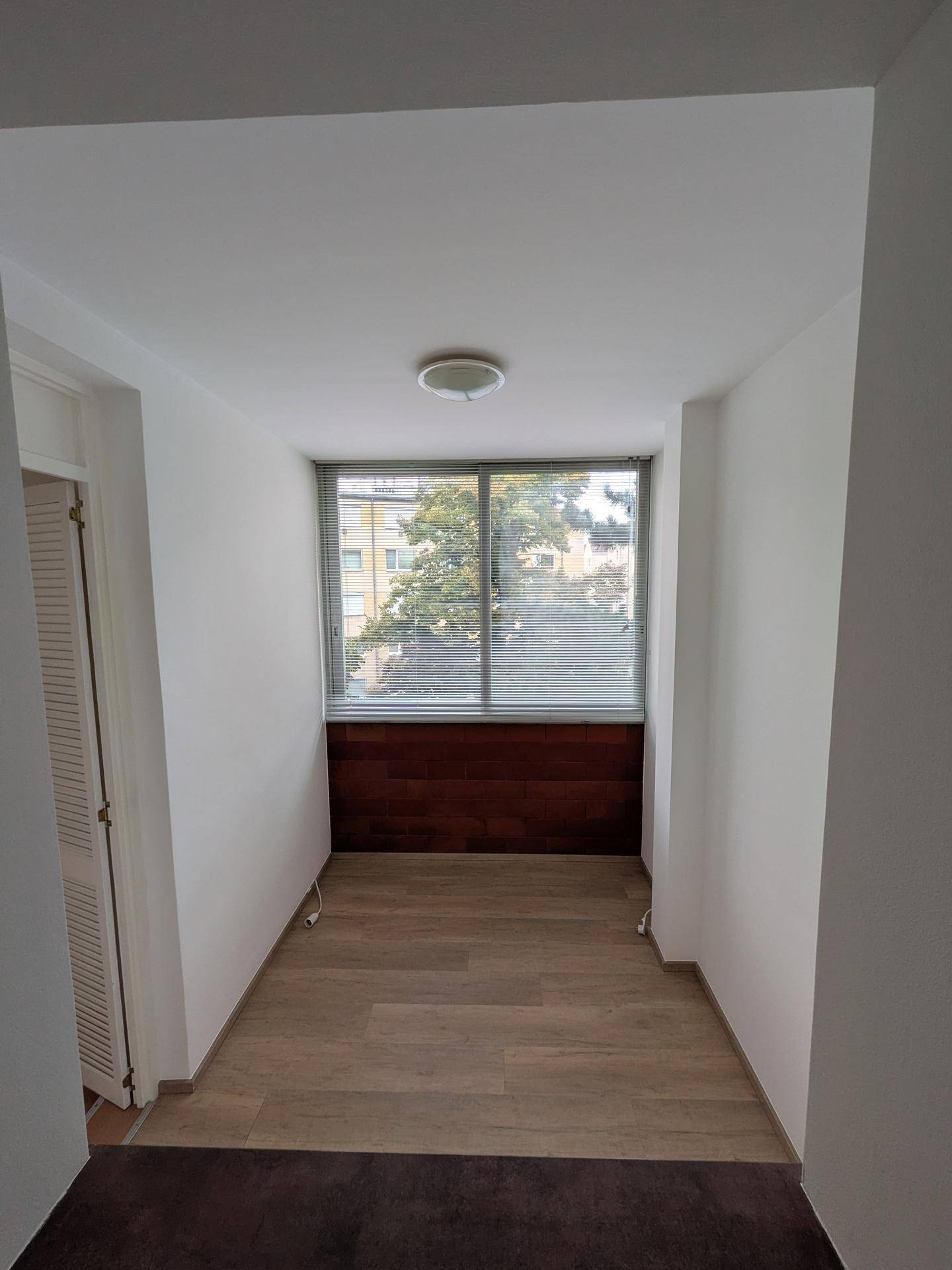 Geschlossene Loggia mit Fenster und Jalousien, bietet zusätzlichen Wohnraum.
