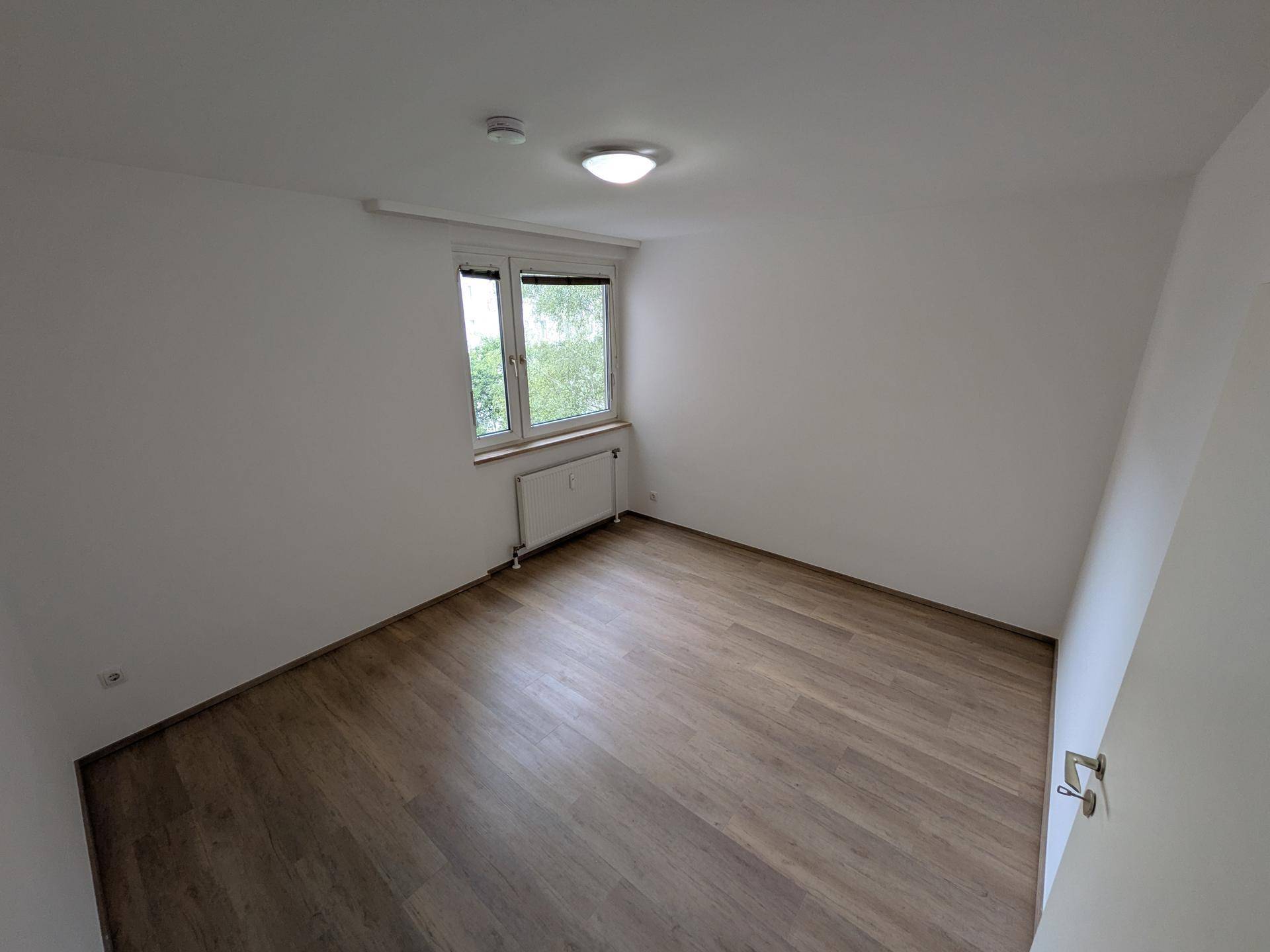 Kleineres Zimmer mit Laminatboden und Fenster, ideal als Kinder- oder Arbeitszimmer.