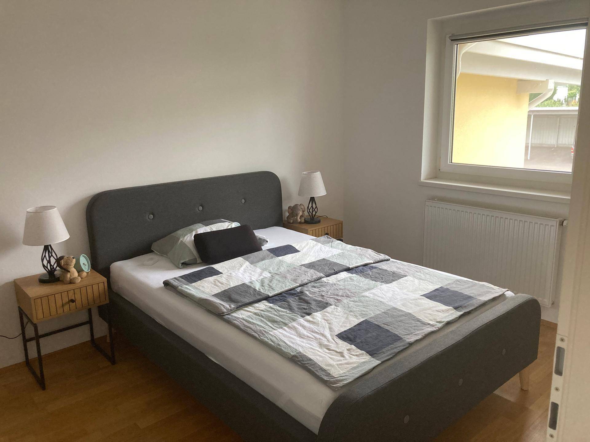 Gemütliches Schlafzimmer mit Doppelbett, Nachttischen und Fenster für natürliches Licht.