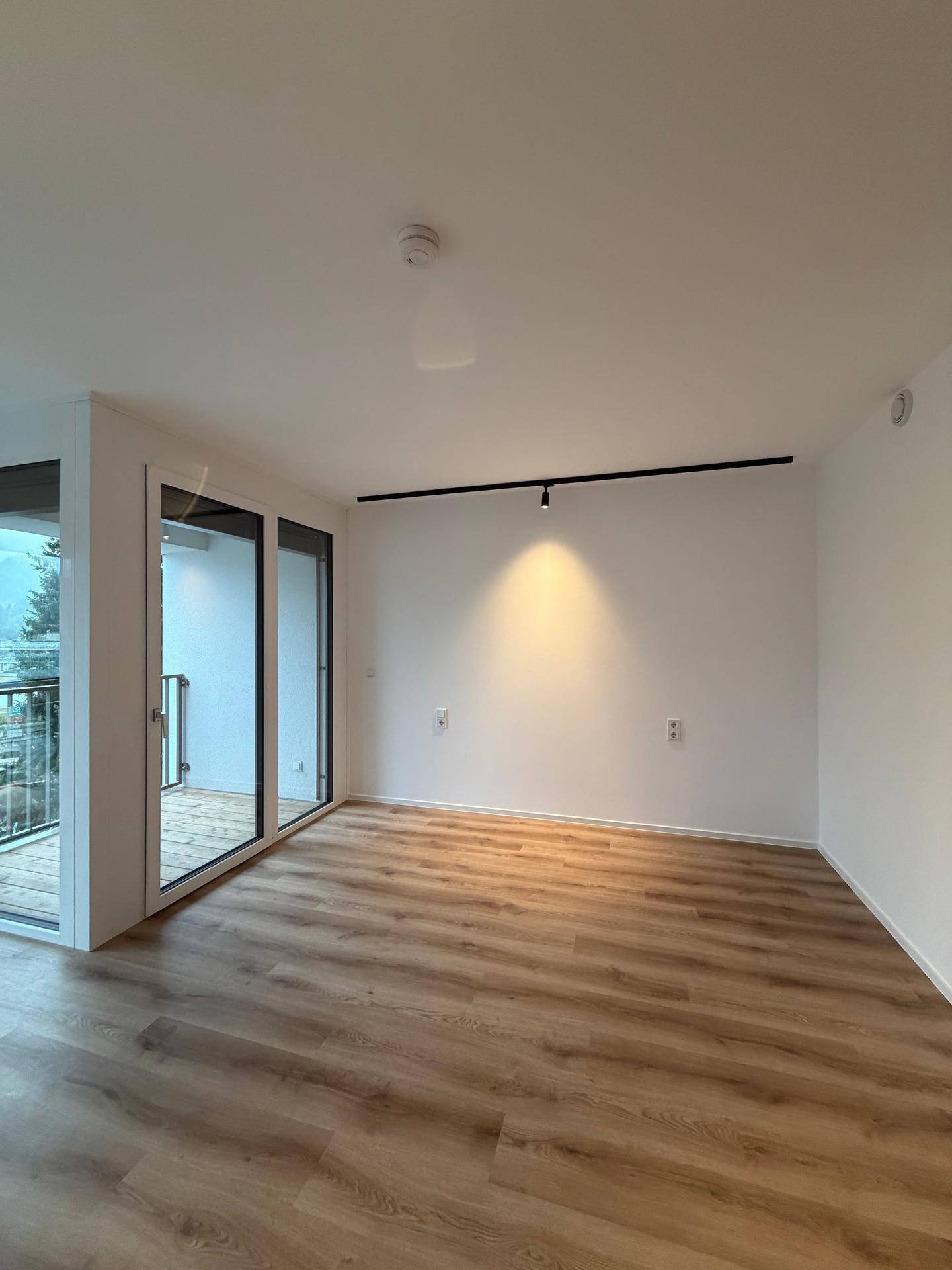 Geräumiges Wohnzimmer mit viel Tageslicht und direktem Zugang zum Außenbereich.