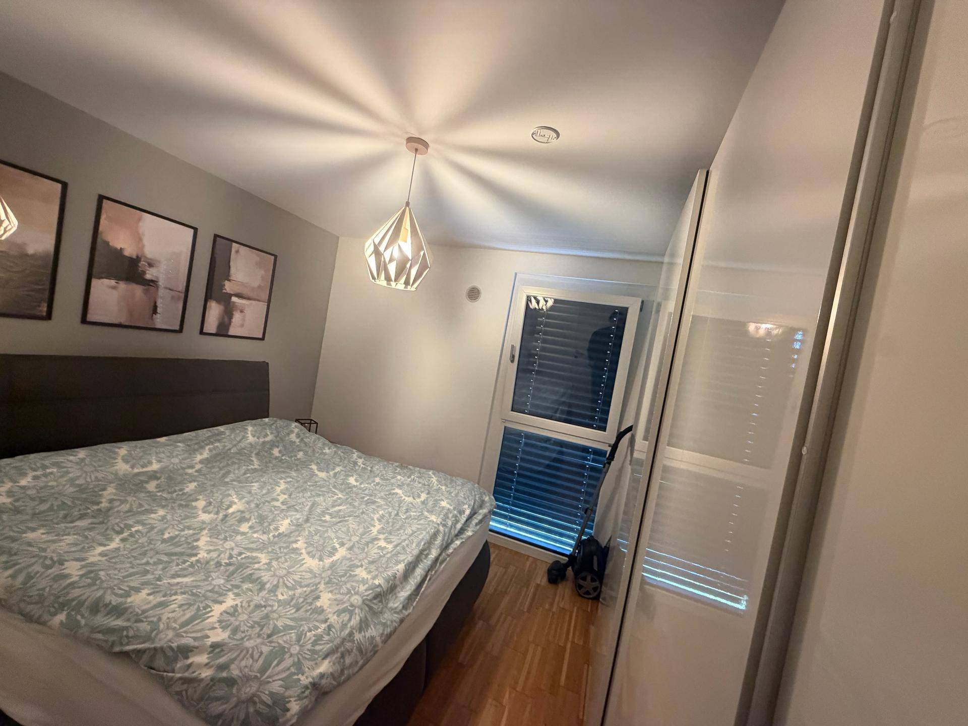 Gemütliches Schlafzimmer mit Doppelbett, Holzparkett und großem Kleiderschrank.