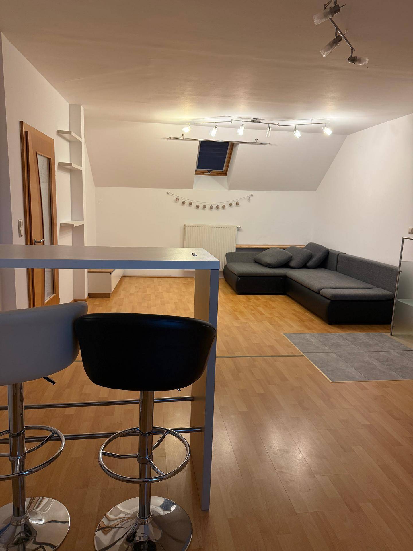 Gemütliches Wohnzimmer mit Ecksofa, Bar und Dachfenster, ideal für entspannte Abende.